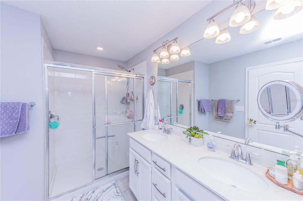220 Evertree Loop Sanford, FL 32771 - Photo 15 of 31 a bathroom with a granite countertop sink a mirror a vanity and a shower