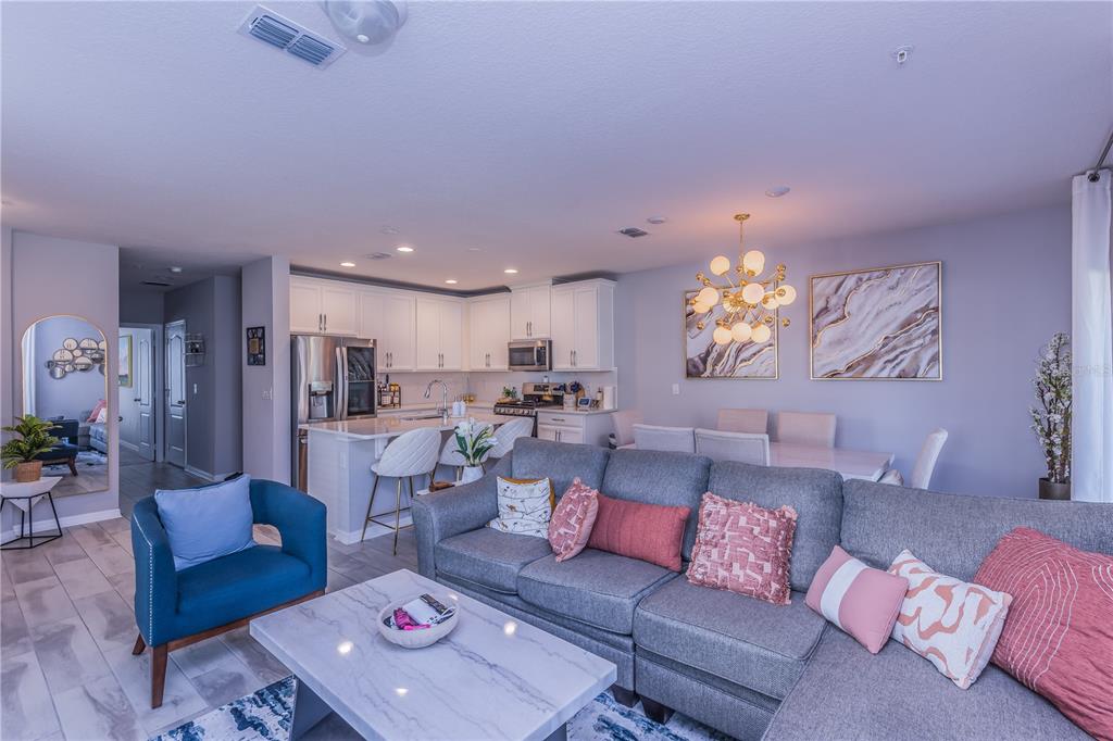 220 Evertree Loop Sanford, FL 32771 - Photo 9 of 31 a living room with furniture and a dining table with kitchen view