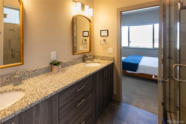 a bathroom with a granite countertop sink and a mirror