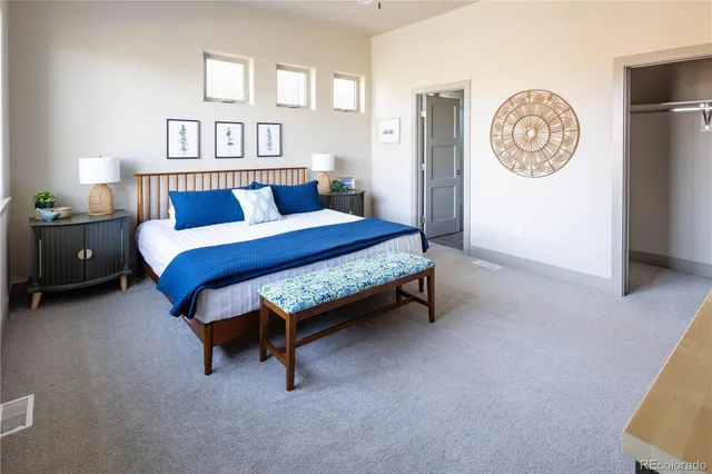 a bedroom with a bed and a lamp on dresser