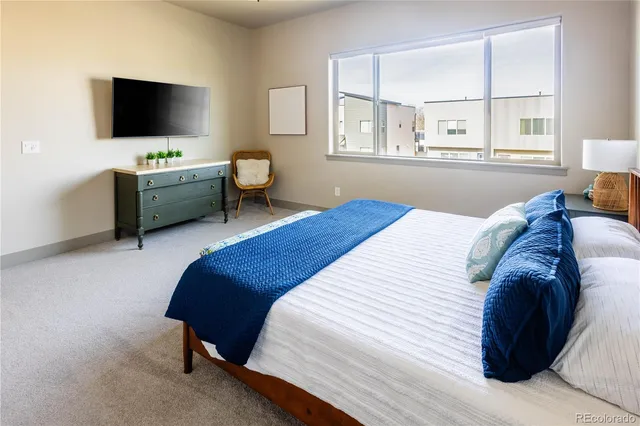 a bedroom with a bed and a flat screen tv