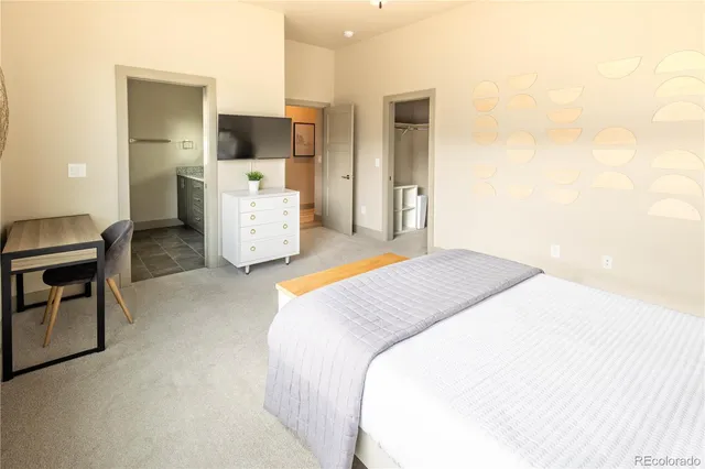 a spacious bedroom with a bed and a chair