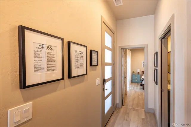 a view of hallway with livingroom and wooden floor