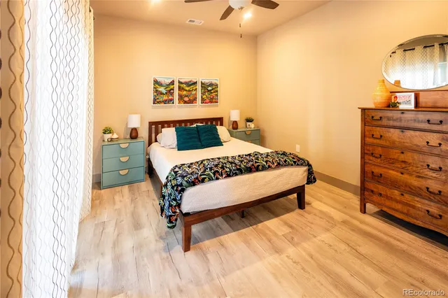 a bedroom with a bed window and a lamp on table
