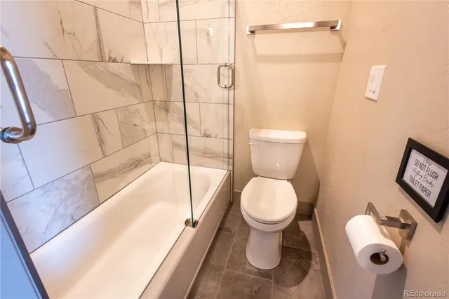 a bathroom with a toilet and a shower