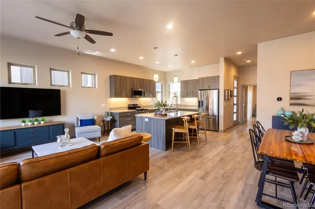 a living room with furniture kitchen view and a flat screen tv