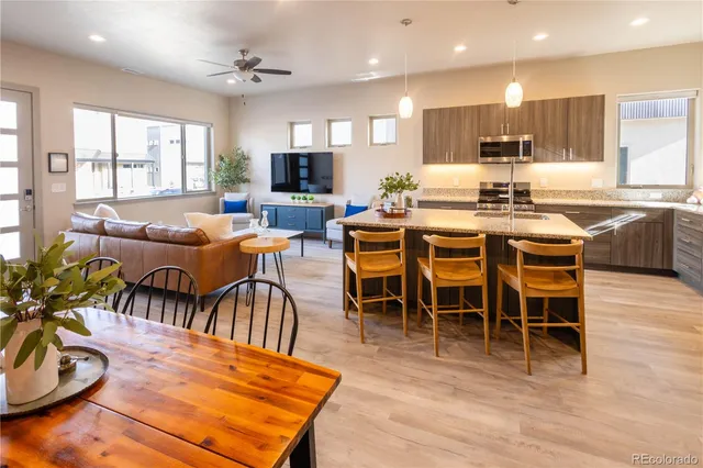 a kitchen with kitchen island granite countertop wooden floor a center island a dining table and chairs