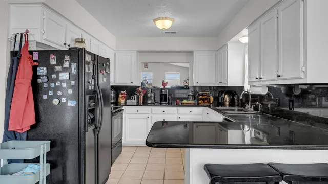 a kitchen with a refrigerator and a stove top oven