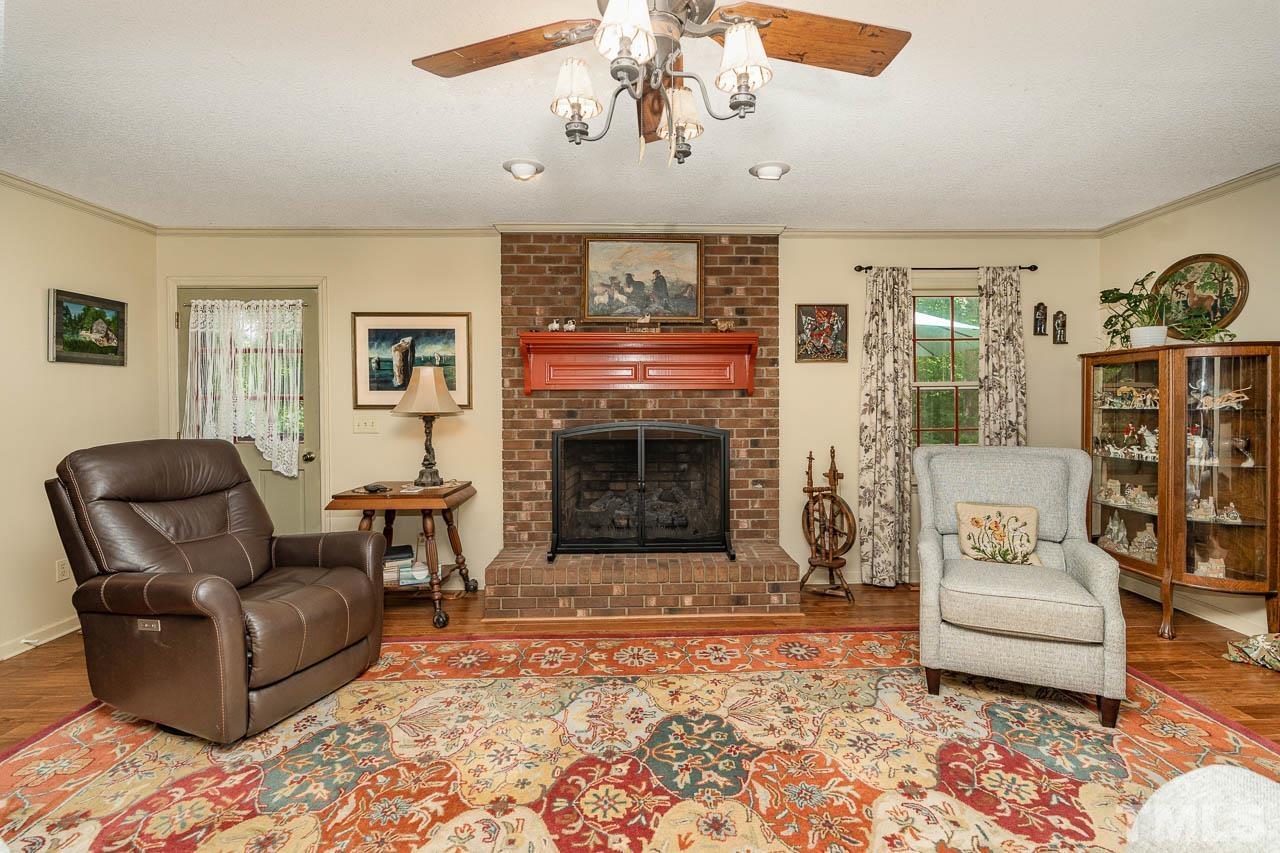 2025 Valley Ridge Court Raleigh, NC 27603 - Photo 15 of 32 a living room with furniture a fireplace and a chandelier