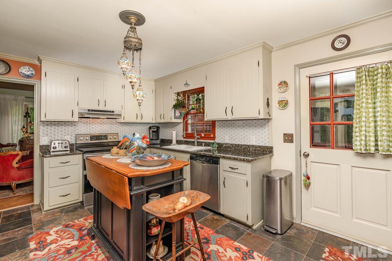 2025 Valley Ridge Court Raleigh, NC 27603 - Photo 21 of 32 a kitchen with stainless steel appliances granite countertop a stove top oven a sink a counter space and cabinets