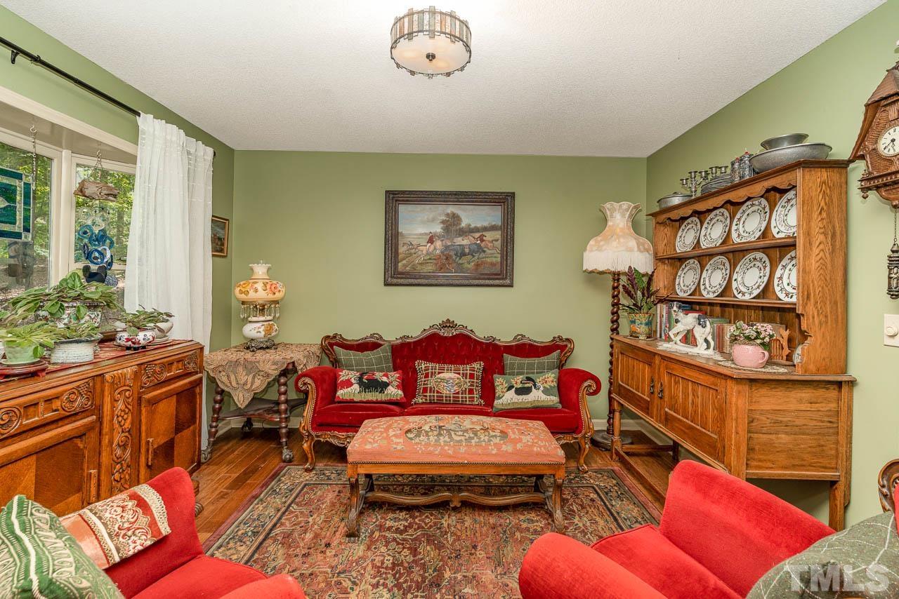 2025 Valley Ridge Court Raleigh, NC 27603 - Photo 24 of 32 a living room with furniture a rug and a wall painting