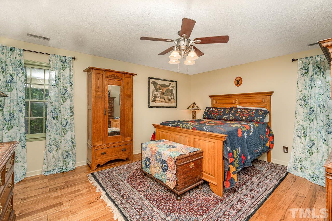2025 Valley Ridge Court Raleigh, NC 27603 - Photo 27 of 32 a bedroom with a bed and wooden floor