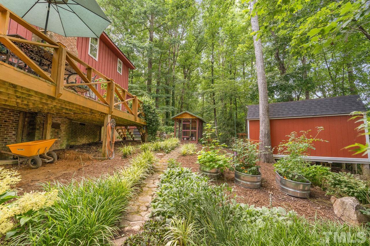 2025 Valley Ridge Court Raleigh, NC 27603 - Photo 10 of 32 a backyard of a house with table and chairs under an umbrella