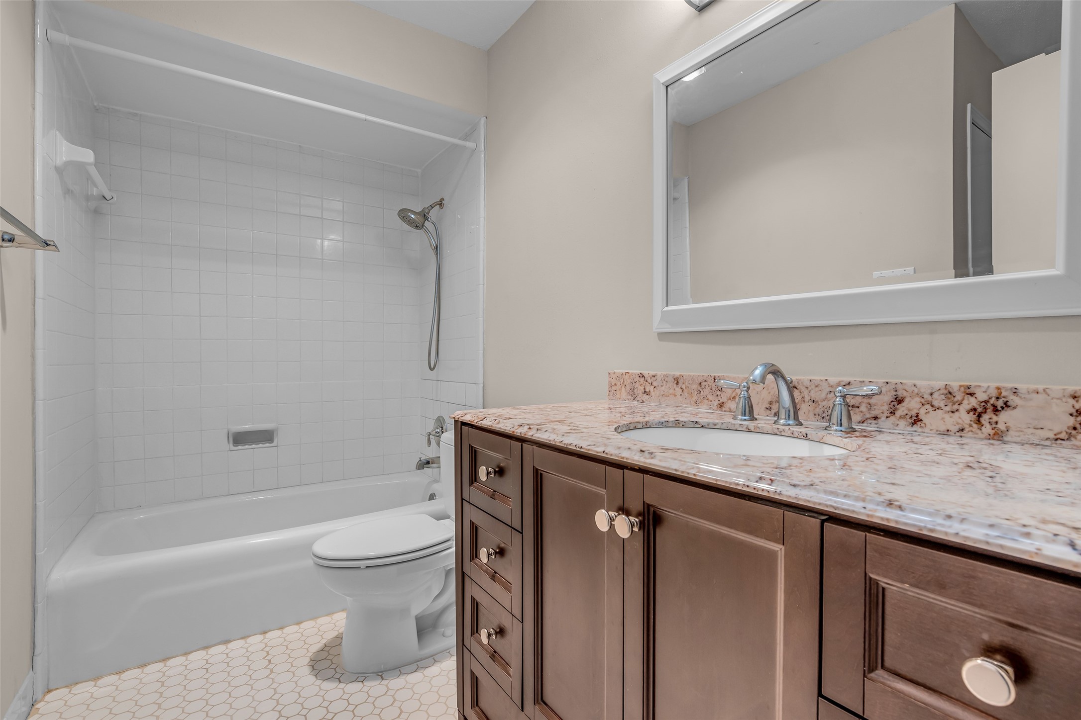 7485 Brompton Street, Unit 7485 Houston, TX 77025 - Photo 33 of 43 Upstair bathroom features a clean, tiled shower-tub combo, a stylish countertop with a modern sink, and ample storage with dark wood cabinetry.
