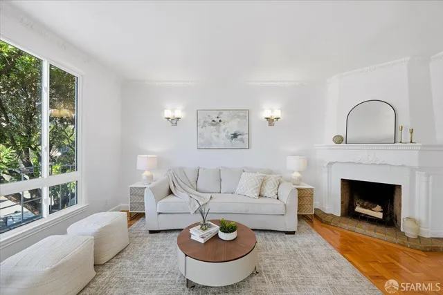a living room with furniture a fireplace and wall painting