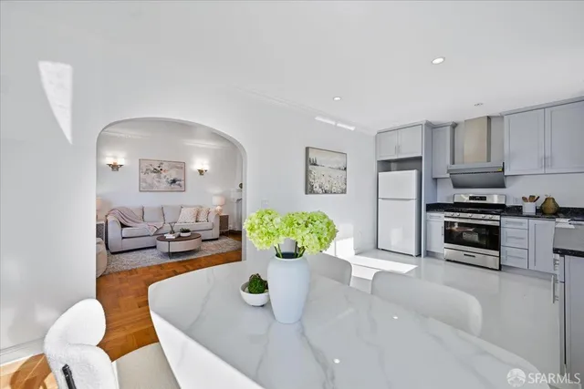 a kitchen with granite countertop white cabinets and stainless steel appliances