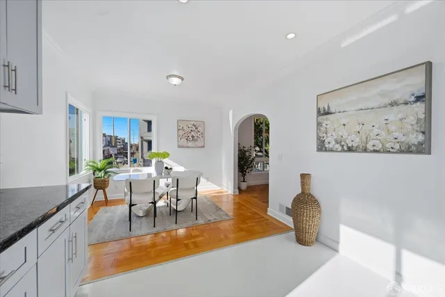 a spacious bedroom with a bed and wooden floor