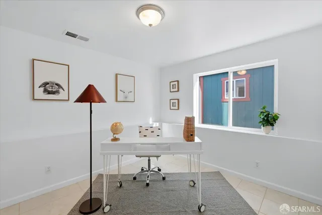 a bedroom with a large bed and a potted plant