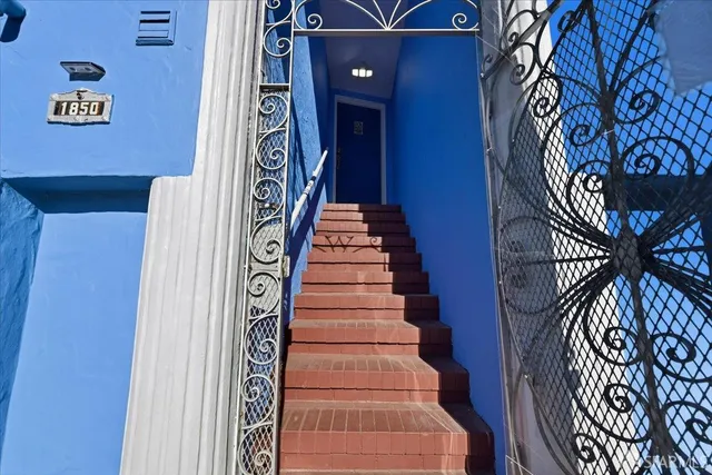 a view of a hallway with wooden floor and a living room