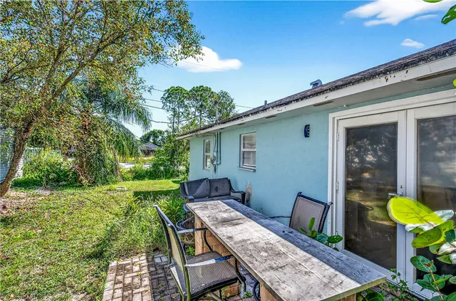 a backyard of a house with table and chairs