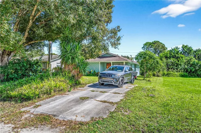a view of a house with backyard sitting area and garden
