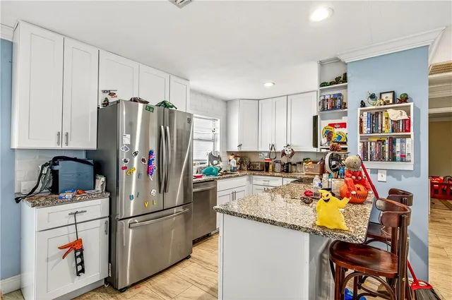 a view of a kitchen with fridge and workspace