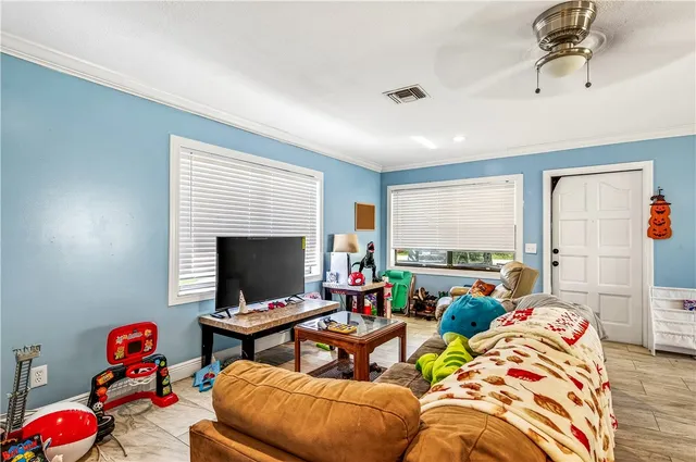a living room with furniture a flat screen tv and a window