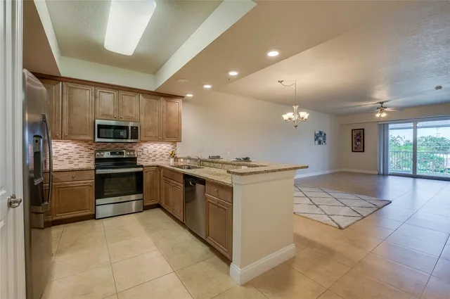 a view of kitchen and kitchen with granite countertop cabinets