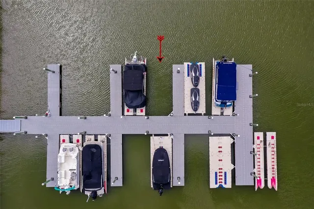 a kitchen with stainless steel appliances kitchen island granite countertop a table chairs in it and wooden floors