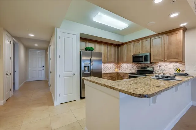 a kitchen with granite countertop a sink stainless steel appliances and cabinets