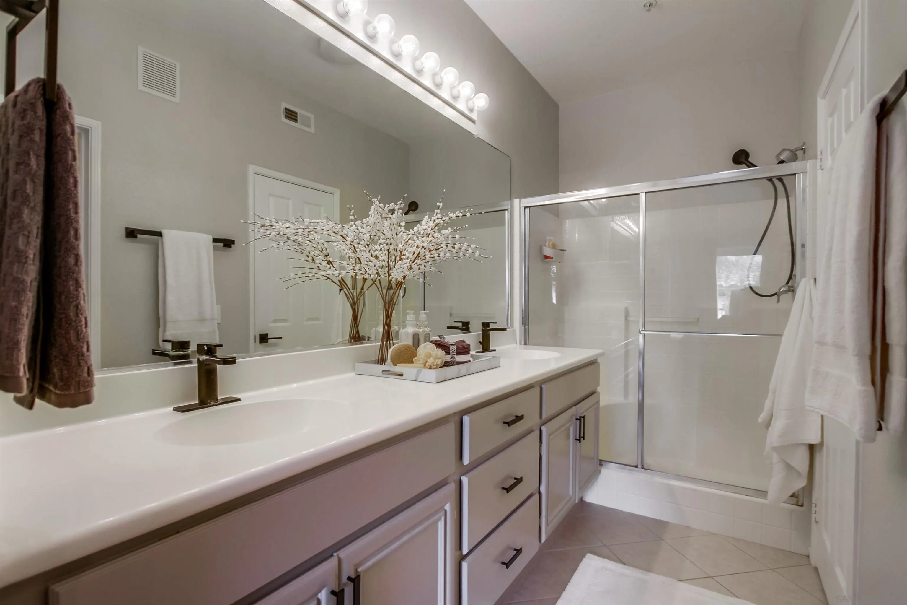 3147 Via Puerta Carlsbad, CA 92009 - Photo 20 of 32 a bathroom with a double vanity sink mirror and shower