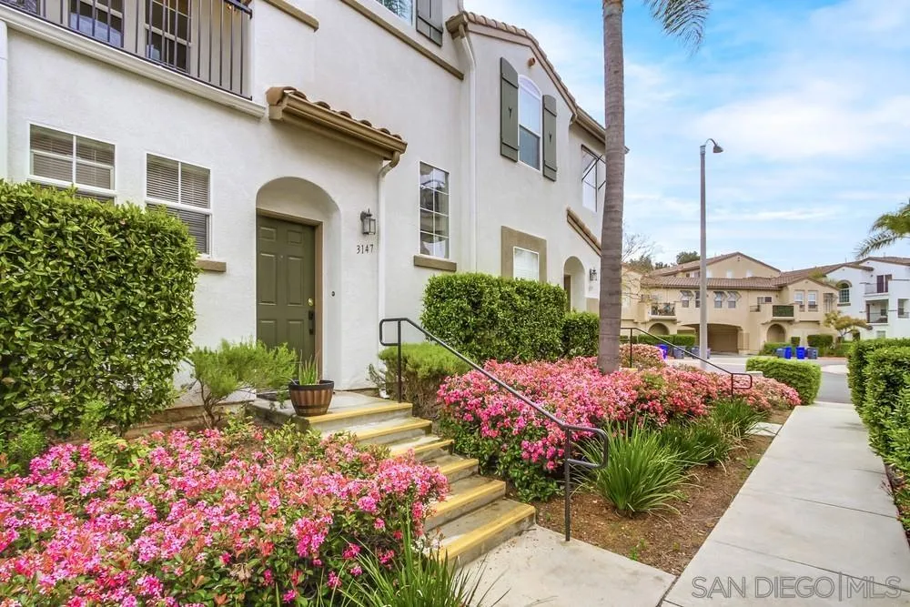 3147 Via Puerta Carlsbad, CA 92009 - Photo 2 of 32 a front view of a house with a yard and flowers