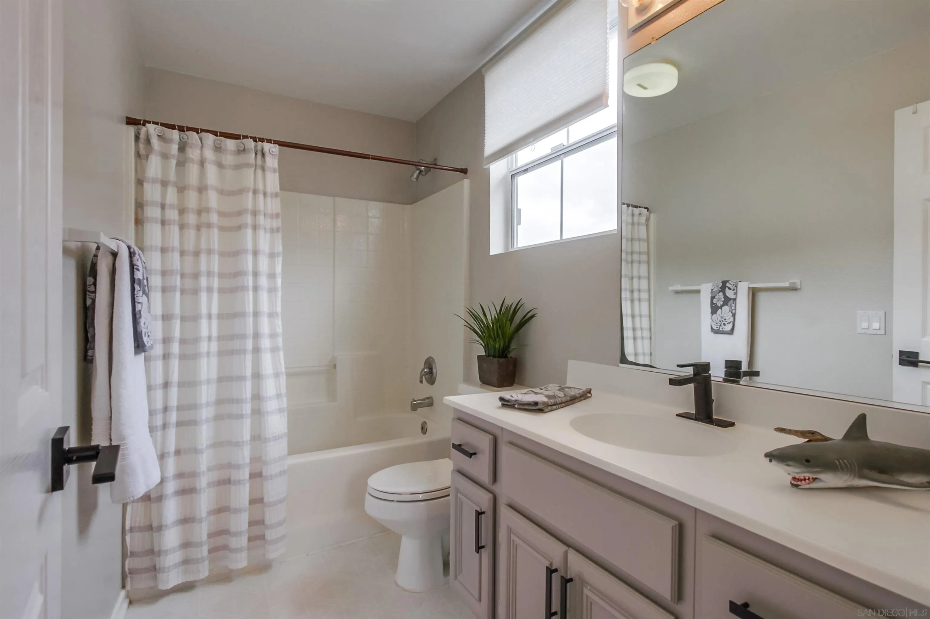 3147 Via Puerta Carlsbad, CA 92009 - Photo 24 of 32 a bathroom with a sink a toilet a mirror and shower