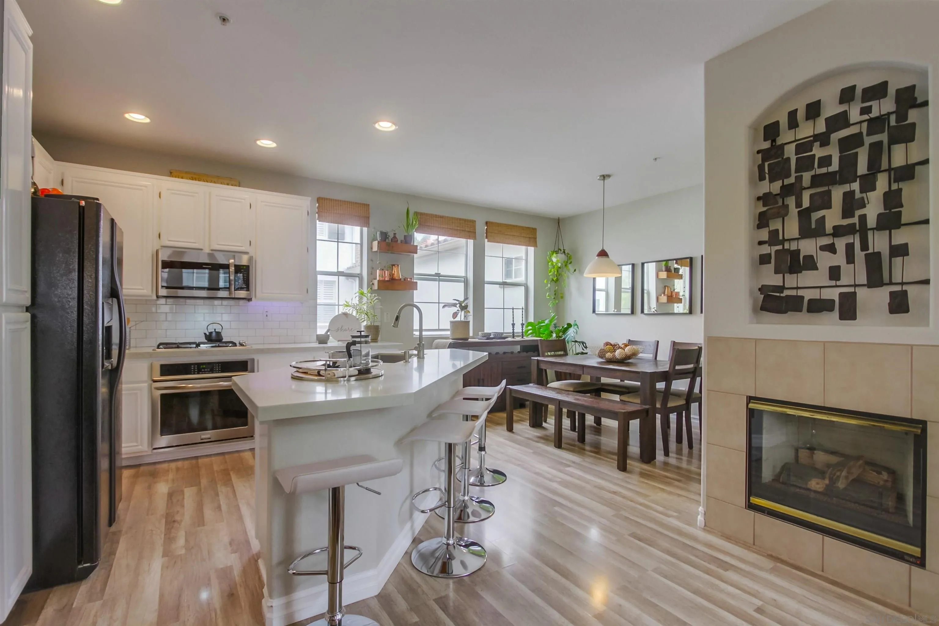 3147 Via Puerta Carlsbad, CA 92009 - Photo 10 of 32 a kitchen with stainless steel appliances a dining table and chairs in it