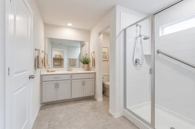 a spacious bathroom with a glass door shower a sink and a mirror