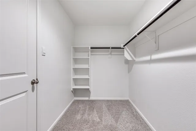 a view of a room that has wooden floor and bench in it