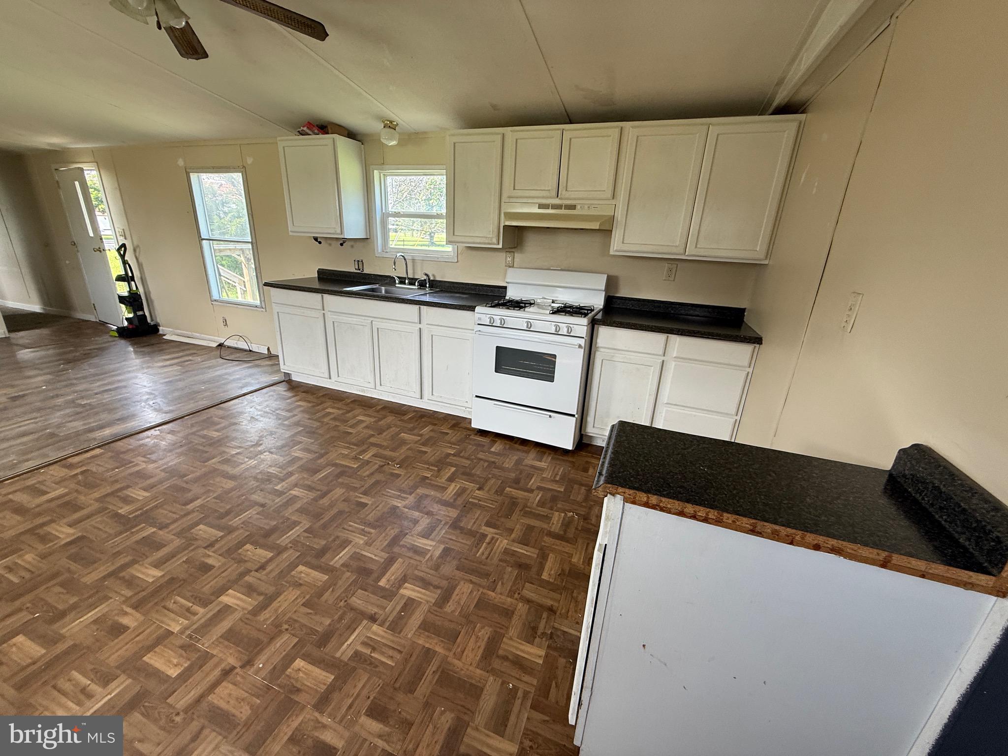 16 Abbotts Pond Road Greenwood, DE 19950 - Photo 5 of 19 a kitchen with granite countertop a stove a sink a microwave and cabinets