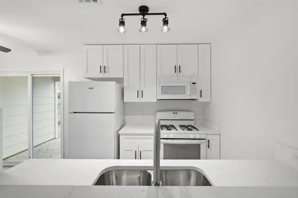 a kitchen with a refrigerator stove and white cabinets