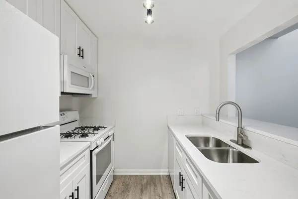 a kitchen with stainless steel appliances granite countertop a sink a stove and refrigerator