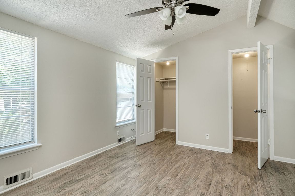 2711 St Edwards Circle, Unit 1 Austin, TX 78704 - Photo 9 of 14 Unfurnished bedroom featuring a textured ceiling, light wood finished floors, a walk in closet, and ceiling fan