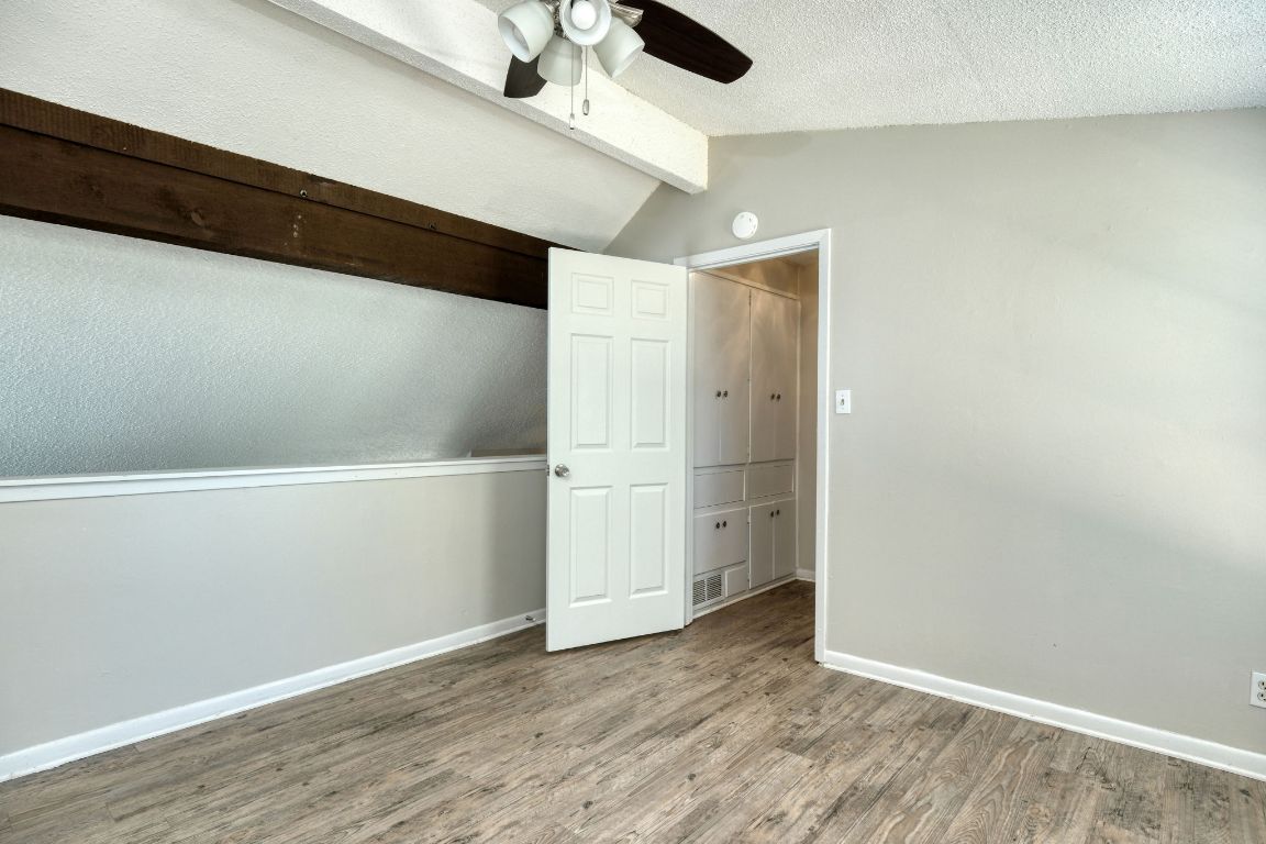 2711 St Edwards Circle, Unit 1 Austin, TX 78704 - Photo 10 of 14 Unfurnished bedroom with wood finished floors, a ceiling fan, and a textured ceiling