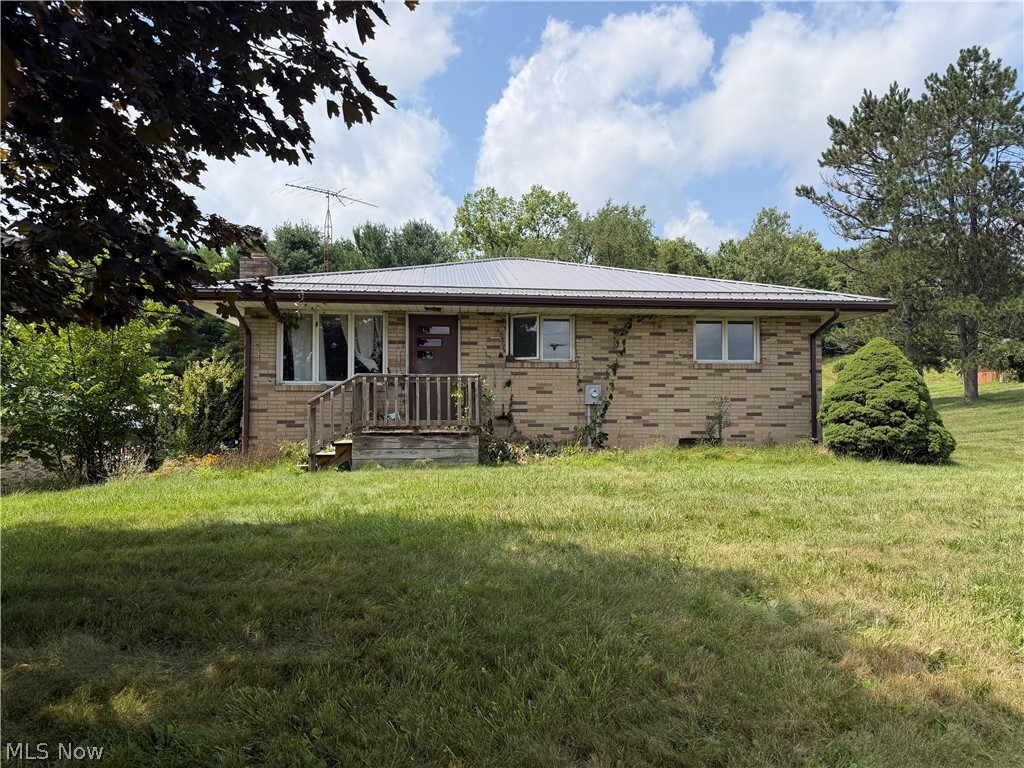 3246 Tabor Ridge Road Northeast Mineral City, OH 44656 - Photo 1 of 29 Brick exterior, metal roof, front porch with wooden railings, multiple windows