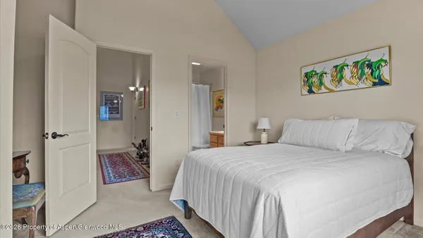 a bedroom with a bed and a painting on the wall