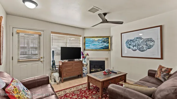 a living room with furniture a flat screen tv and a fireplace