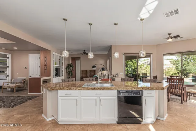 a kitchen with kitchen island granite countertop a sink cabinets and stainless steel appliances
