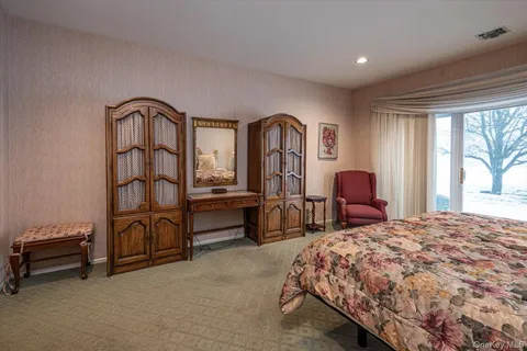 a bedroom with a bed a dresser next to a window
