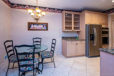 a kitchen with stainless steel appliances granite countertop a dining table and chairs