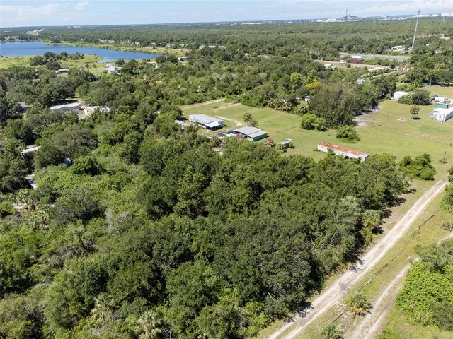 an aerial view of residential houses with outdoor space and trees