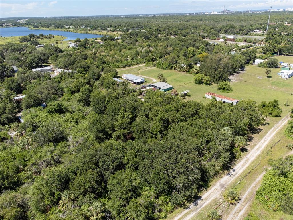 an aerial view of residential houses with outdoor space and trees