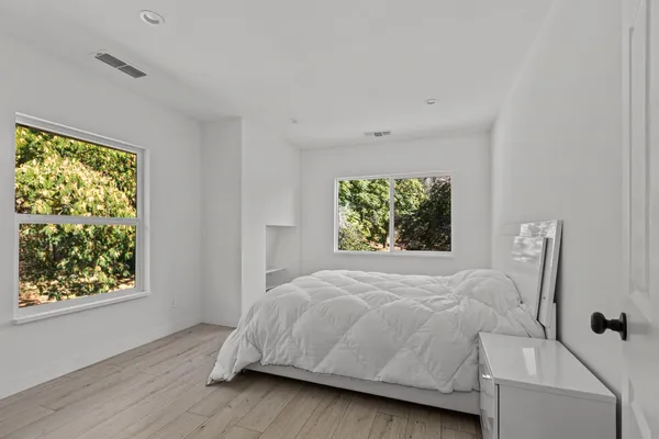 a bathroom with a sink mirror toilet and next to a window